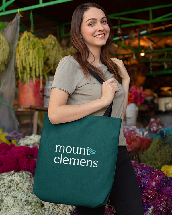 Image of woman wearing Mount Clemens tote bag.