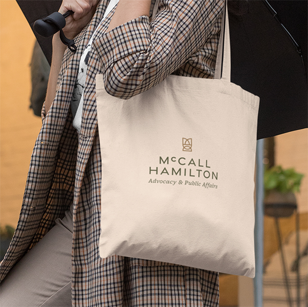 Woman wearing a McCall Hamilton branded tote bag.