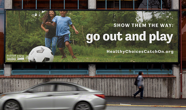 Billboard of mom and son playing soccer together