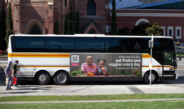 Bus ad of mom and daughter eating fruits and veggies