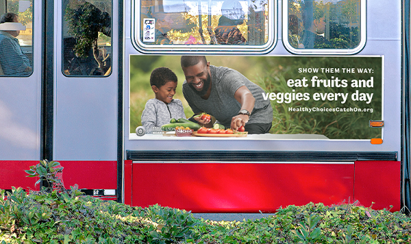 Bus ad of father and son slicing veggies