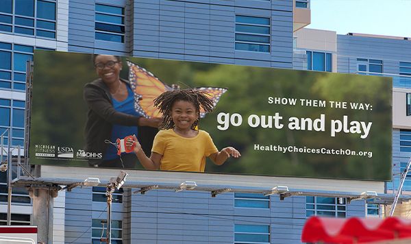 Billboard of mom and daughter flying a kite