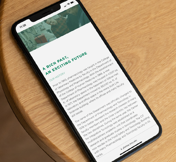 Phone displaying the MSU Department of Pharmacology and Toxicology website