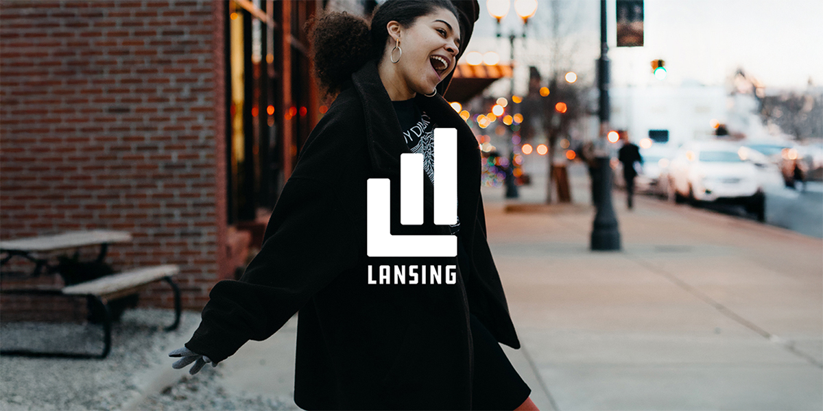 Image of woman dancing in Lansing streets with campaign logo overlayed on top.