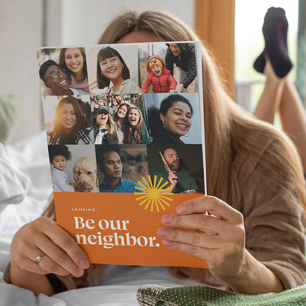 Person holding up booklet cover featuring the campaign design