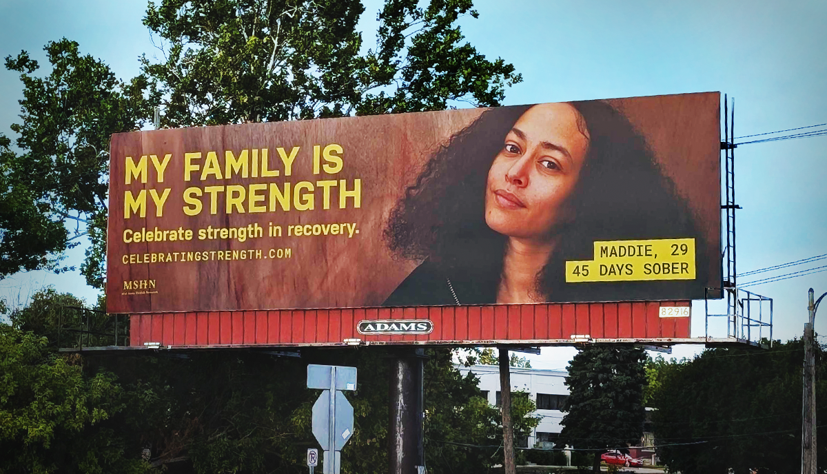 A billboard with an image of a woman reads "My family is my strength."